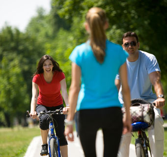 People bicycling and walking in park
